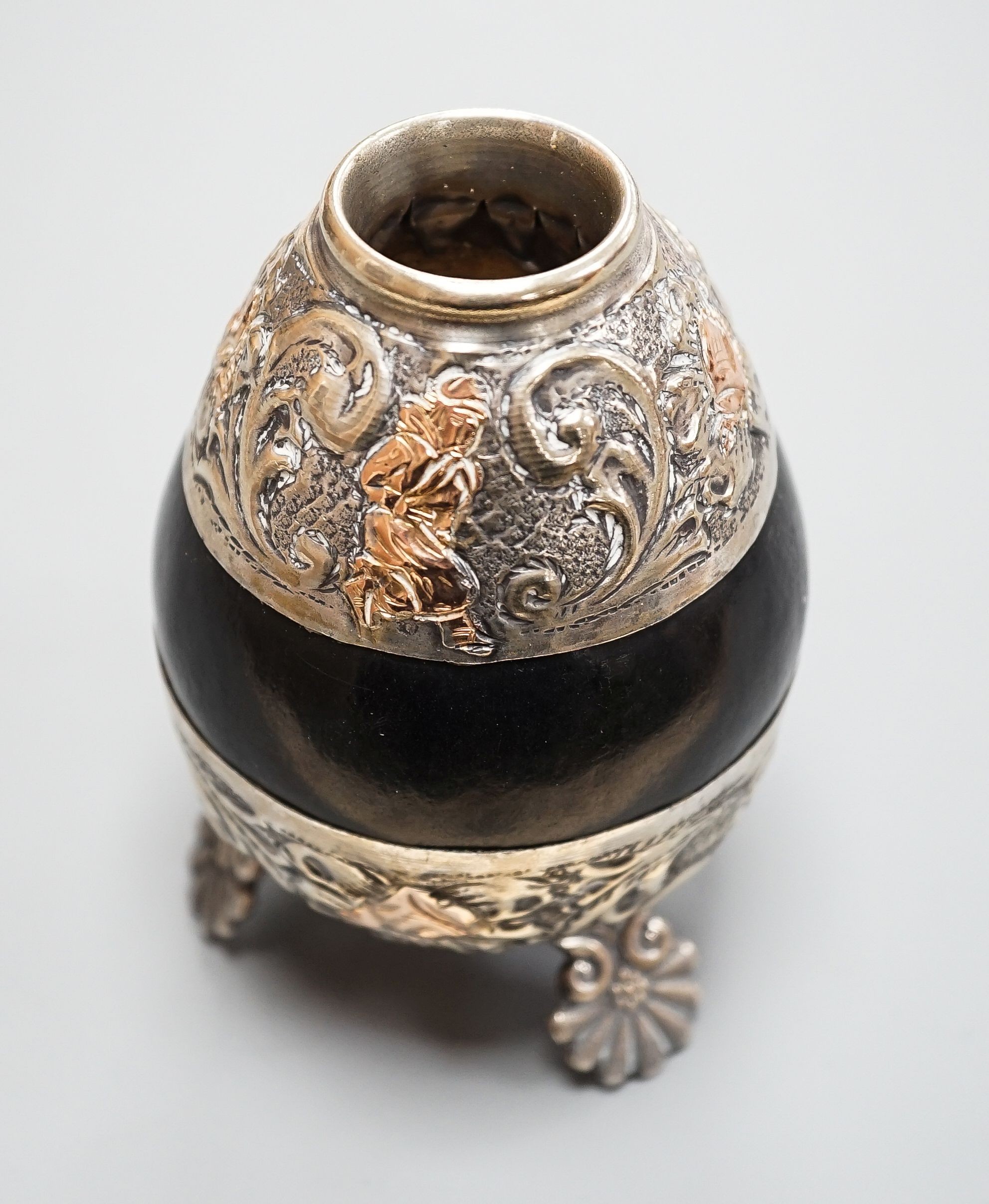 A 20th century maté cup gourd with white and yellow metal repoussé decoration, height height 10cm.